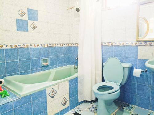 y baño azul con aseo y bañera. en Negros Haven Seaside Resort, en Jayugan
