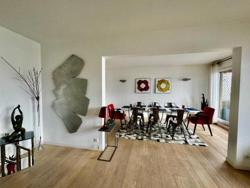una sala da pranzo con tavolo e sedie in una stanza di chez Nathalie a Boulogne-Billancourt
