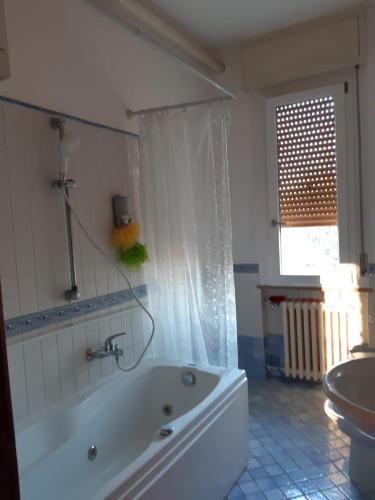 a white bathroom with a tub and a sink at La casa in più in Pesaro