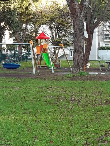 a playground in a park with a tree at La casa in più in Pesaro