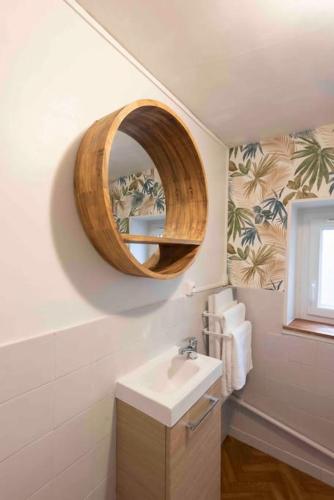 une salle de bain avec un lavabo et un miroir dans l'établissement Spacieux- Le clos Lingon, à Mâcon