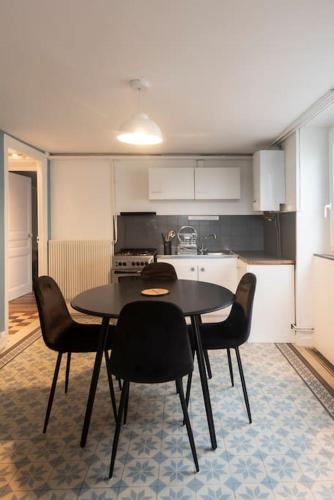 une cuisine avec une table et des chaises dans une pièce dans l'établissement Spacieux- Le clos Lingon, à Mâcon