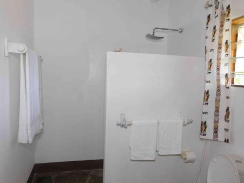 a bathroom with a toilet and towels on a wall at Holiday home in Malindi in Mambrui