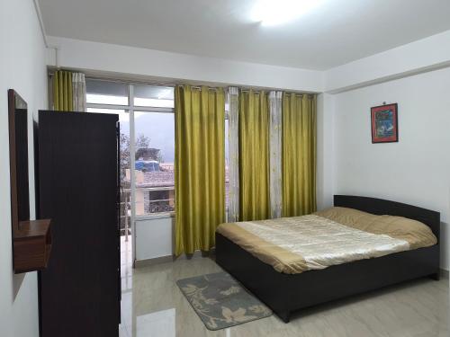 1 dormitorio con cama y ventana grande en Natures Life urban homestay, en Gangtok