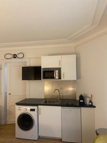 une cuisine avec un micro-ondes et un lave-linge dans l'établissement Studio opéra paris, à Paris