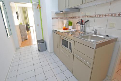 una pequeña cocina con fregadero y encimera en Modernes 1-Zimmer-Appartement im Kurgebiet von Bad Kreuznach, en Bad Kreuznach