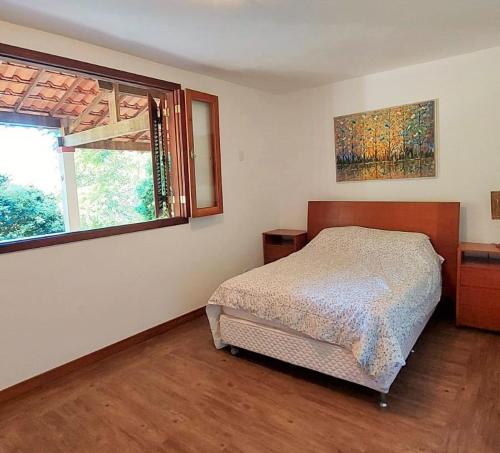 um quarto com uma cama e uma janela em Fazenda Santa Luzia em Além Paraíba