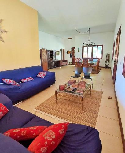 uma sala de estar com sofás azuis e uma mesa em Fazenda Santa Luzia em Além Paraíba