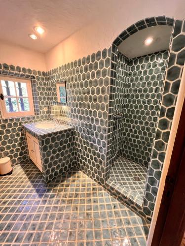 une salle de bain avec douche aux carreaux gris dans l'établissement La Mandarine, à Rayol-Canadel-sur-Mer