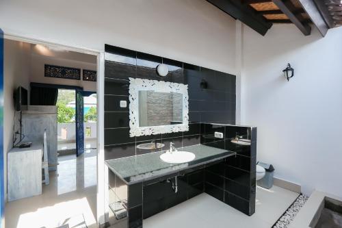Cozy Bungalows في غيلي تراوانغان: حمام أسود مع حوض ومرآة