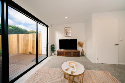 a living room with a tv and a large window at Charming Retreat in the Heart of Christchurch City-CBD 