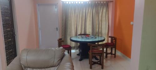 ein Wohnzimmer mit einem Tisch, Stühlen und einem Sofa in der Unterkunft Arpan Home Stay in kolkata