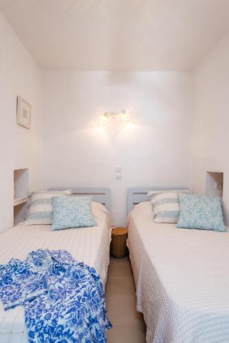 two beds sitting next to each other in a bedroom at Stunning Sunset House on Kamares Bay with Playground in Kamarai