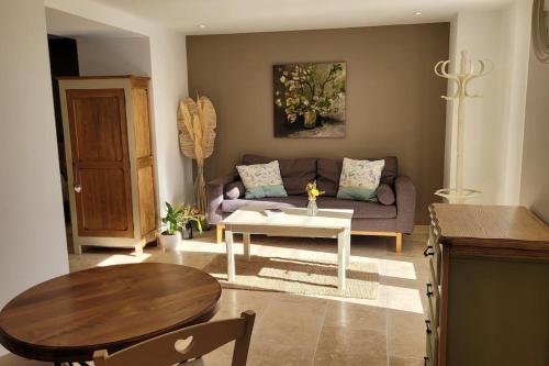 sala de estar con sofá y mesa en Gîte La Genestière au milieu des vignes, piscine partagée, en Mazan