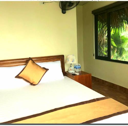 um quarto com uma cama com uma almofada e uma janela em Ngòi Xanh Ecolodge (Bungalow - Restaurant - Coffee) em Tuyên Quang