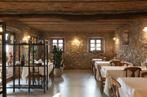 comedor con mesas, sillas y paredes de piedra en Cascina Belvedì, en Clanezzo