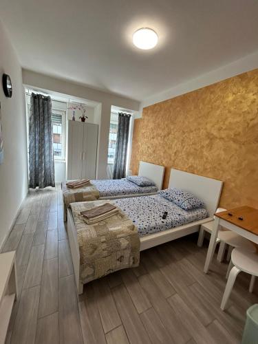 a bedroom with two beds and a table at Capri B&B in Bolzano