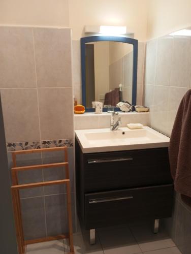 une salle de bain avec un lavabo et un miroir dans l'établissement location T2 Cavalaire sur mer avec piscine, à Cavalaire-sur-Mer