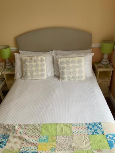a bed with a quilt and pillows on it at Green Apple Bed and Breakfast in St Ives