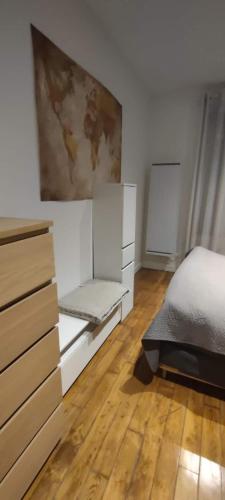 une chambre avec un lit et un tableau au mur dans l'établissement Studio 2 pièce charmant et calme, à Boulogne-Billancourt