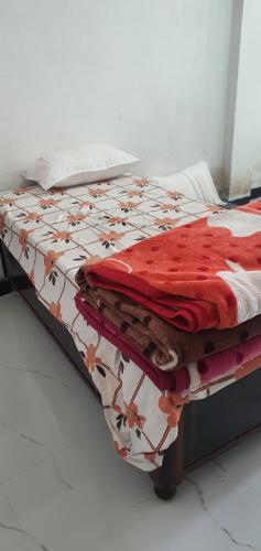 uma cama com um cobertor vermelho e branco em City yatra em Ujaim
