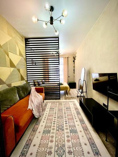 ein Wohnzimmer mit einer Couch und einem Teppich in der Unterkunft Брутальная квартира ЖK Sport Sity LUX in Astana