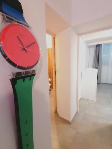a red and green clock on a wall in a room at Casa del Cigno in Monterotondo