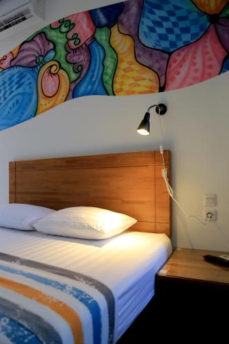 a bedroom with a bed with a painting on the wall at Istanaku Guesthouse 2 in Manado