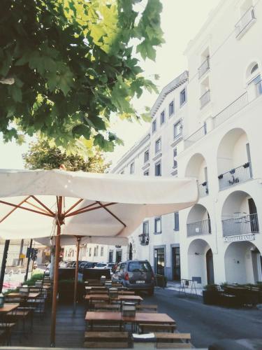a group of tables and umbrellas in front of a building at affittacamere prezioso in Gaeta
