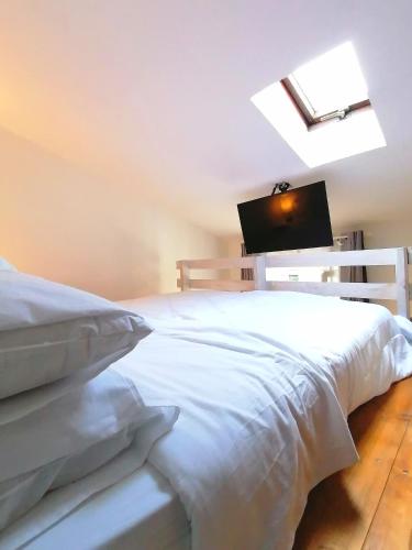a bedroom with a white bed with a flat screen tv at Casa del Cigno in Monterotondo
