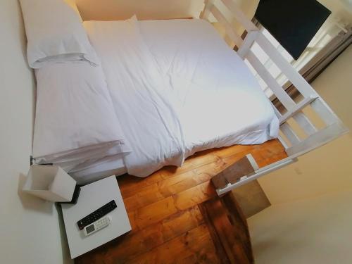 a bed with white sheets and a wooden floor at Casa del Cigno in Monterotondo