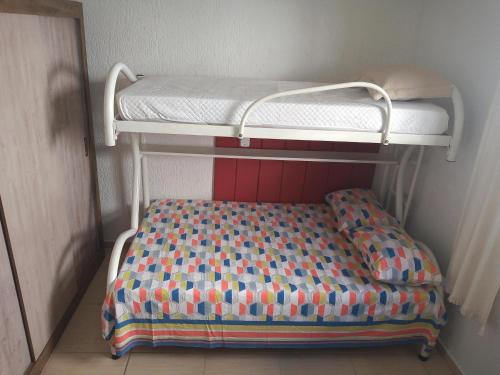 a bunk bed with a colorful blanket on top of it at Recanto do Sossego in Águas de Lindóia