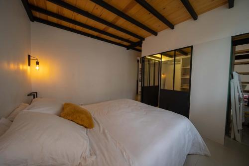 - une chambre avec un lit blanc et un oreiller jaune dans l'établissement Confort hôtelier dans une prestigieuse résidence, à Alger