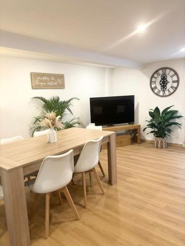 une salle à manger avec une table et des chaises et une télévision dans l'établissement Maison chaleureuse proche Paris, à Châtillon