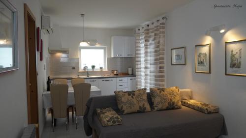a living room with a couch and a kitchen at Apartments Marja in Njivice
