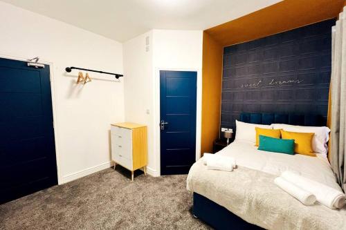 um quarto com uma cama grande e uma cabeceira azul em 4 Beds 3 Bath (2-ensuites) Free Parking 75Mbps em Stoke on Trent