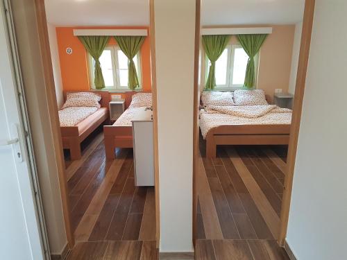 a room with two beds and two windows at Apartment Dora in Gornji Karin
