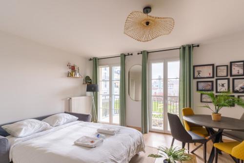een slaapkamer met een bed en een tafel en stoelen bij Élégant & Lumineux - Disneyland Paris in Serris