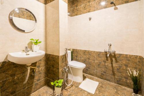 a bathroom with a sink and a toilet and a mirror at Hotel Fortune Hyderabad Airport Zone in Hyderabad