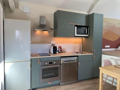 a small kitchen with a refrigerator and a stove at La Martinière in Saint-Martin-sur-Oust