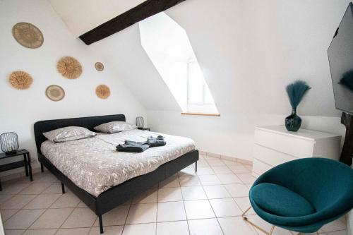 una camera da letto con un letto e una sedia blu di Résidence Le Zola composé de 3 appartements distincts en Hyper Centre de Dijon avec WIFI a Digione