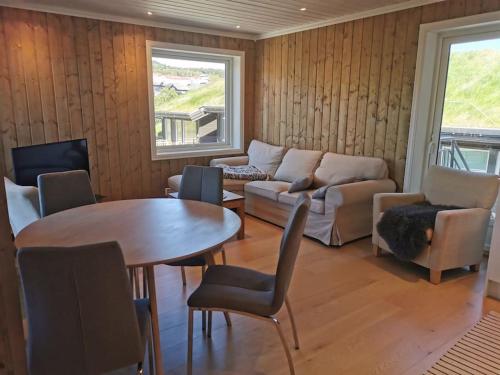 a living room with a couch and a table and chairs at Sentral leilighet på Geilo in Geilo