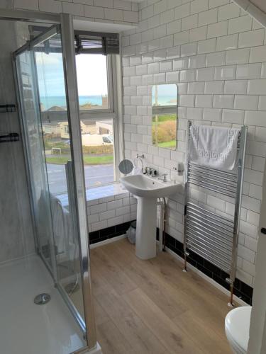 biała łazienka z umywalką i prysznicem w obiekcie Green Apple Bed and Breakfast w St Ives