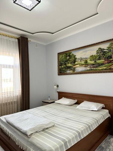 a bedroom with a bed with a painting on the wall at Aral in Nukus