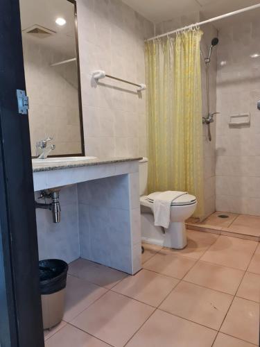 a bathroom with a sink and a toilet and a mirror at Desa Phuket in Phuket