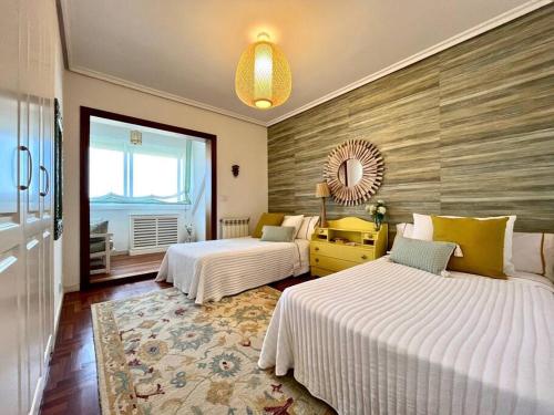 Habitación de hotel con 2 camas y espejo en Luxury House Center Baiona en Baiona