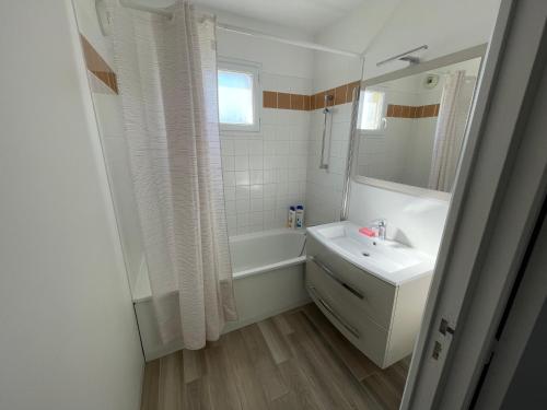 ein Badezimmer mit Waschbecken, Badewanne und Spiegel in der Unterkunft Appartement T2 cabine dans résidence avec piscine proche Honfleur - Deauville - Pont L'evêque in Équemauville