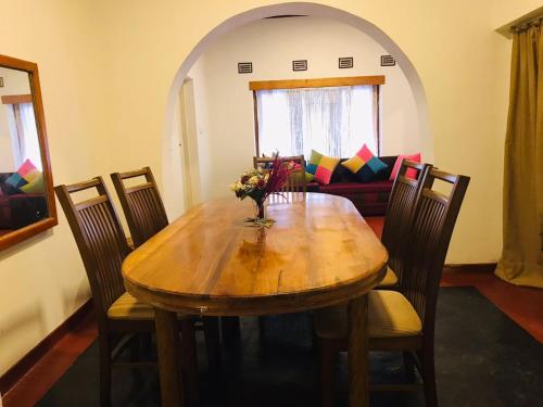 a dining room with a wooden table and chairs at Lodgepole Pine Resorts in Welimada