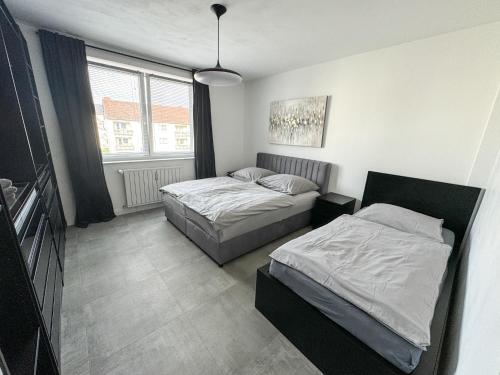 a bedroom with two beds and a window at Moderne 2-Zimmer Wohnung im Zentrum von Wolfsburg in Wolfsburg