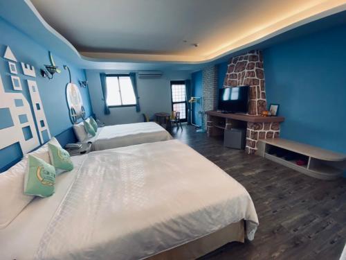 a hotel room with two beds and a fireplace at 墾丁包棟民宿 海景 kenting timehouse beach villa l室內烤肉l k歌l電動麻將l德州l廚房 in Kenting